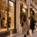 Shoppers outside a fashion store on a Paris street in the evening light.