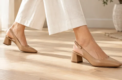 Woman walking in tan leather slingback shoes with a secure heel strap on a light wooden floor.